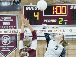 Junior Claire Barlow (3) rises above Swain County’s Kinsley Hyatt during Sept. 21’s road match in Bryson City. Photo by Kevin Hensley/sports@grahamstar.com