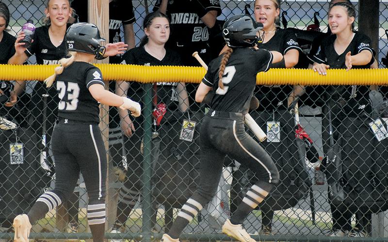 Robbinsville’s Suri Watty (23) and Zoie Shuler (2) run down a line of high-fives from teammates Anna Williams, Liz Carpenter and Delaney Brooms (from left), after Shuler scored the second run of Friday’s fourth-round playoff win at Uwharrie Charter. Photos by Kevin Hensley/sports@grahamstar.com